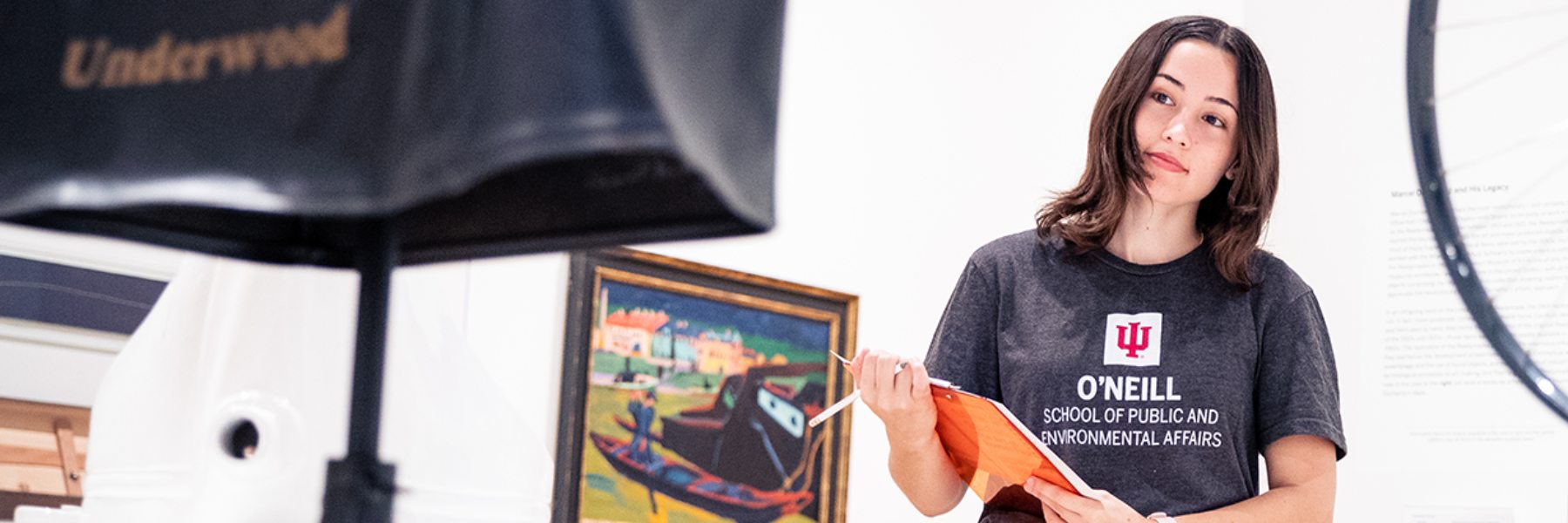 Woman in O'Neill shirt with clipboard in a museum. 