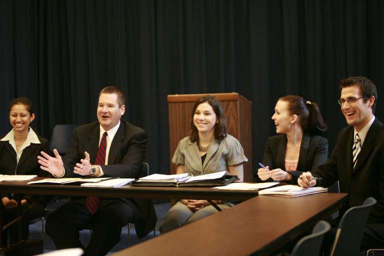 Laughing students around a conference table